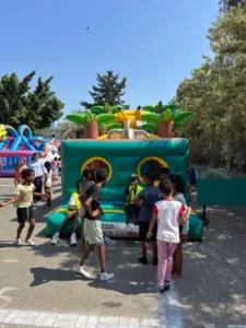 אירוע בית ספר בחוץ עם מתנפחים צבעוניים וילדים משחקים